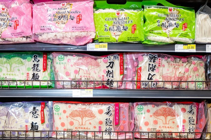 Colorful packages of Asian noodles line the shelves of H Mart.