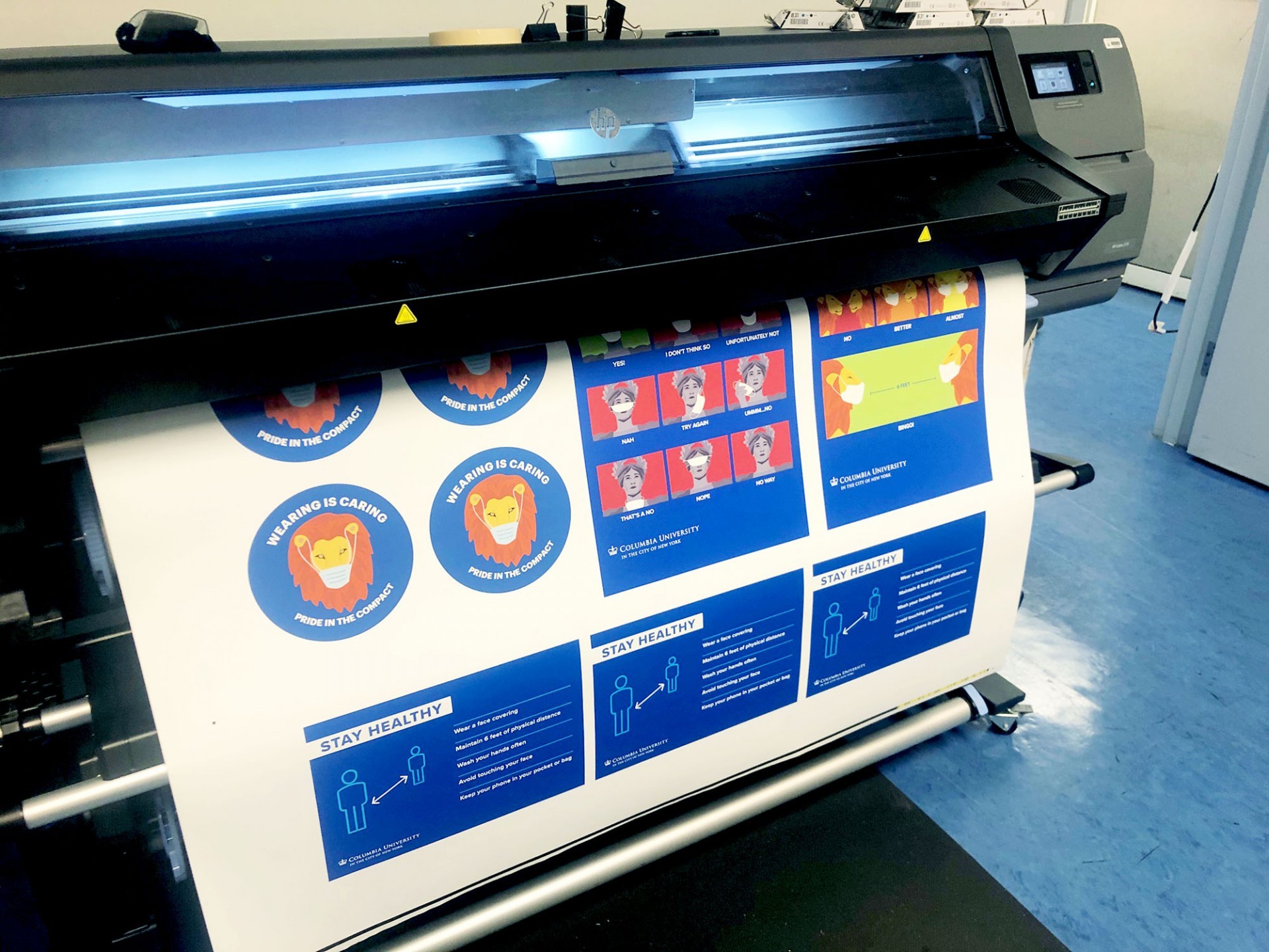 A large printer that has multiple signs printed on the paper.