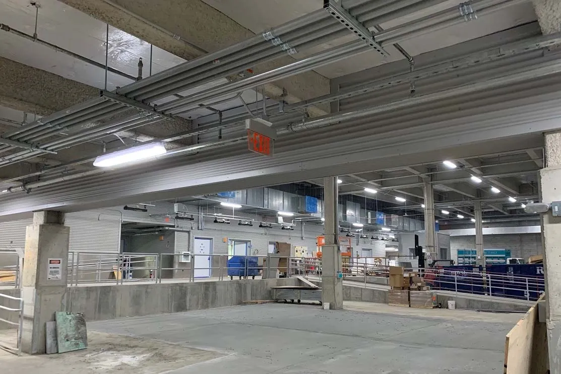 The interior of a loading dock that has numerous pipes running across the ceiling.