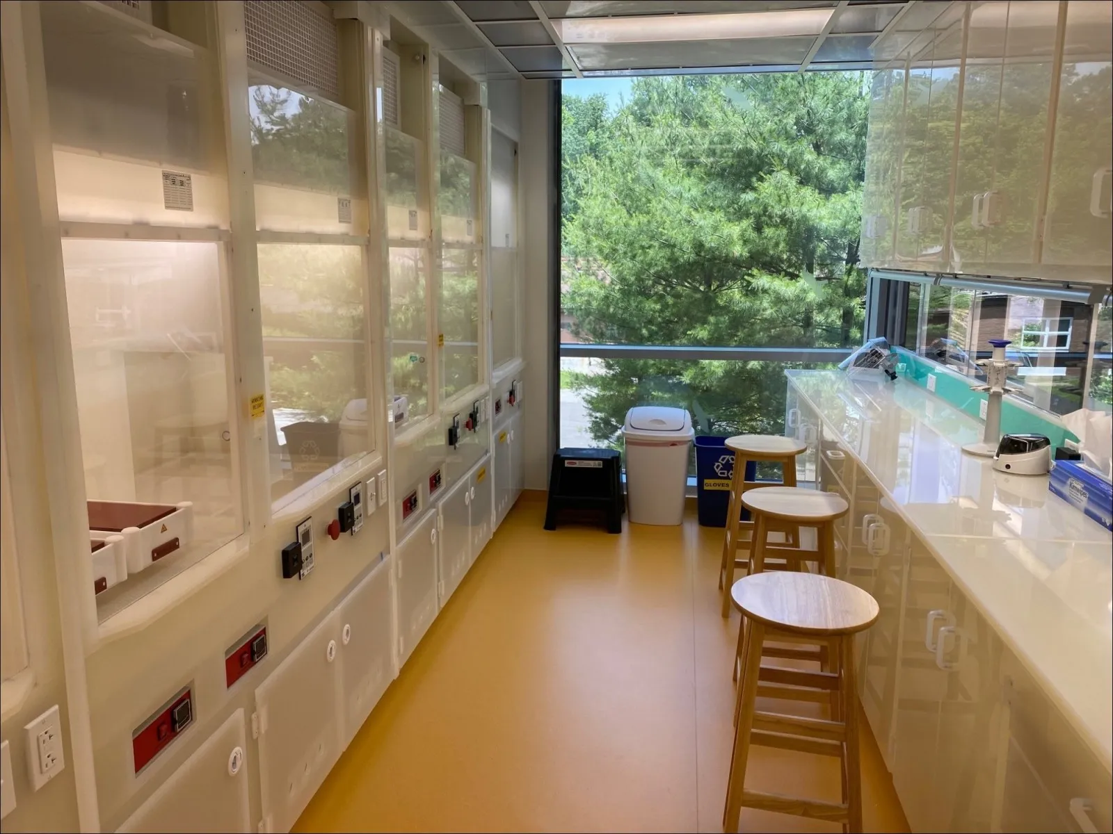 A new clean lab that has wooden bar stools alongside the workbench.