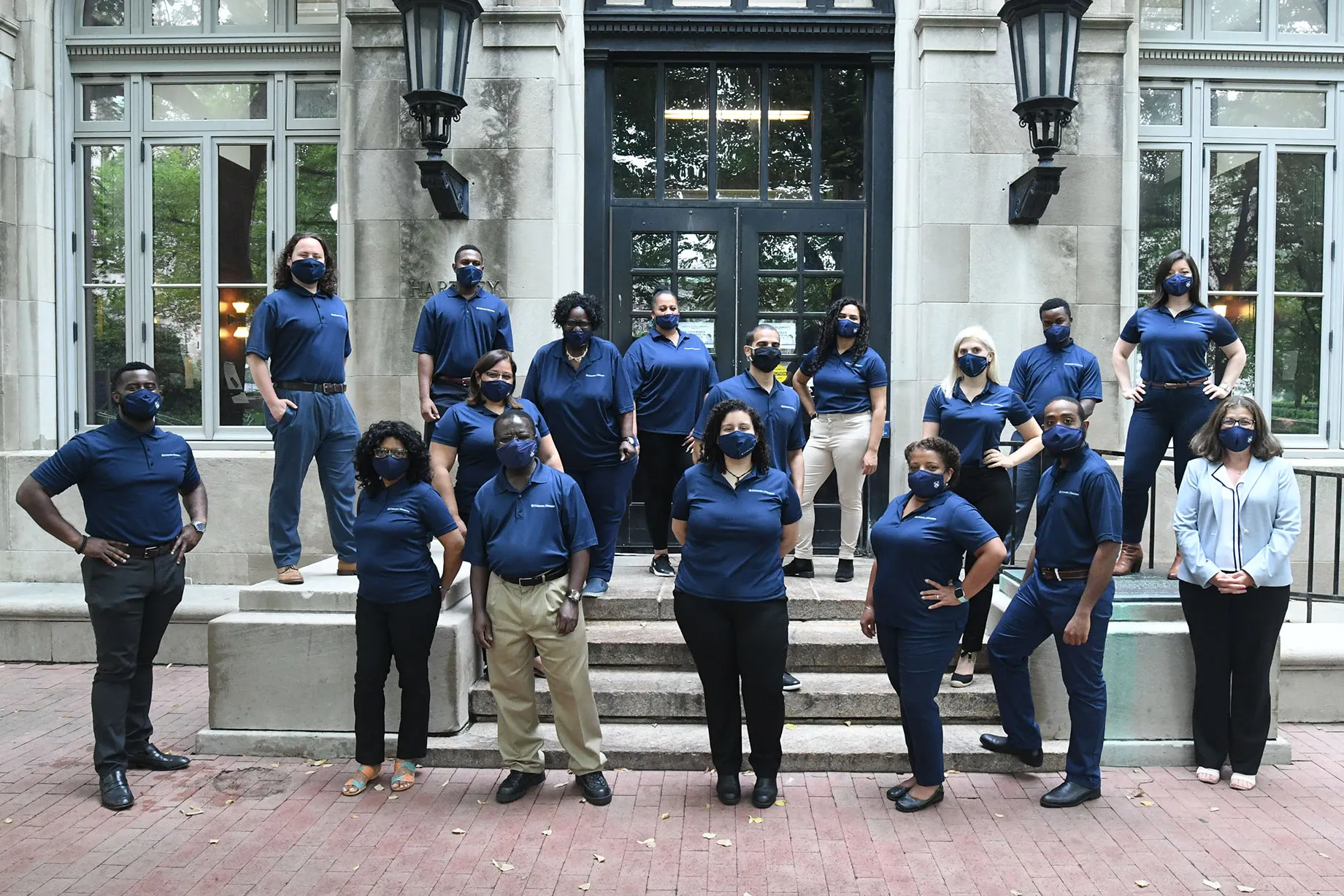 The Columbia Housing team stands and smiles outside the entrance of one of the residence halls.
