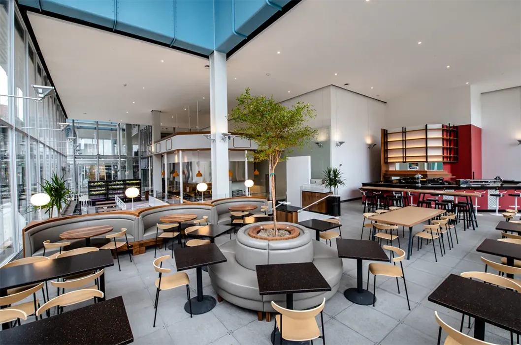 The inside of Manhattanville Market, a food hall with different kiosks set up around the room.