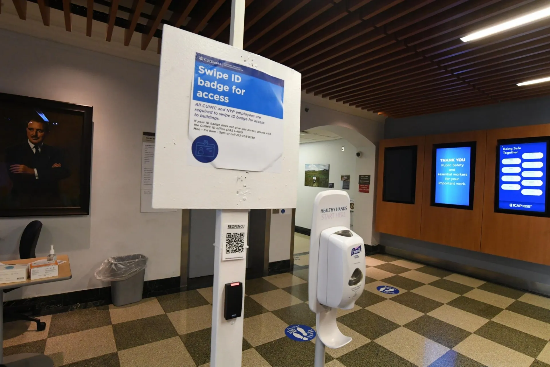 A posted sign in a building lobby that says to swipe ID badge for access.
