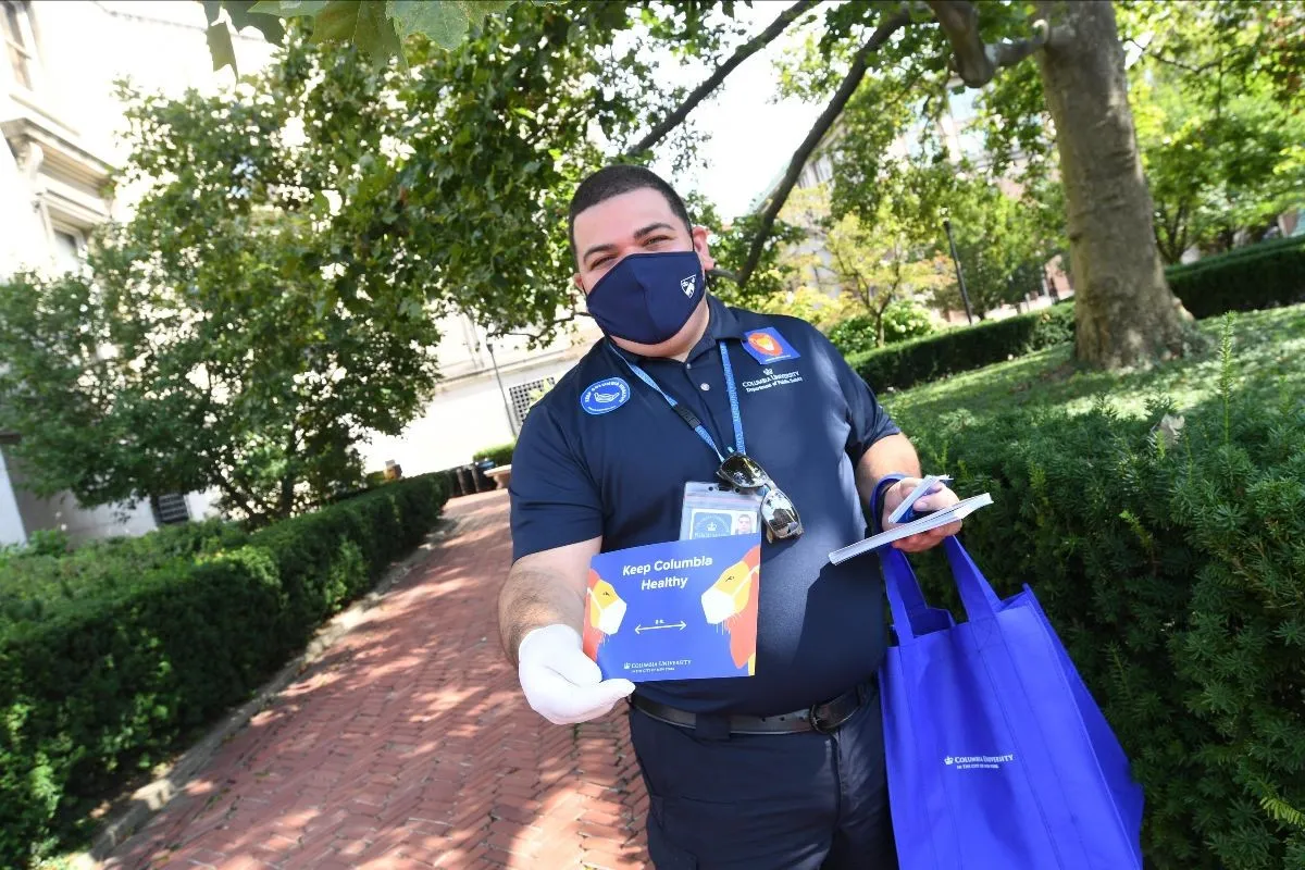 A Columbia employee holds out a brochure that says Keep Columbia Healthy